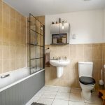 Modern bathroom with bath, sink, and toilet.