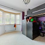 Children's bedroom with loft bed and purple decor.