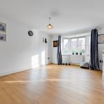 Bright room with wooden floor and large window.