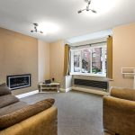 Cosy living room with sofa and large window.