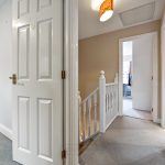 Upstairs hallway with open doors and staircase