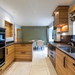 Modern kitchen interior with wooden cabinets and dining area.