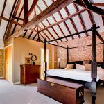 Cosy bedroom with wooden beams and stone walls.