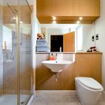 Modern bathroom with shower, sink, and toilet.