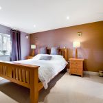 Modern bedroom with wooden furniture and double bed.