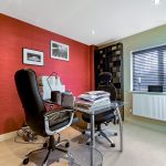 Modern home office with red accent wall.