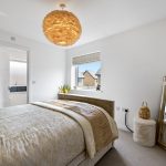 Modern bedroom with elegant decor and window view.