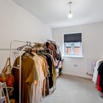 Spacious wardrobe room with organised clothes racks.
