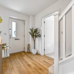 Bright, modern hallway with wooden flooring.