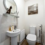 Small modern bathroom with sink and toilet.