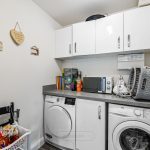 Laundry room with appliances and storage cabinets.