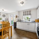 Modern kitchen with wooden dining table and chairs.