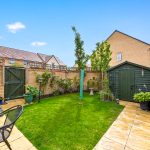 Sunny garden with shed and patio area.