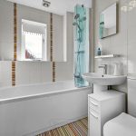 Modern white bathroom with shower and colourful tiles.
