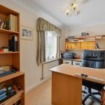 Home office with desk, shelves, and printer.