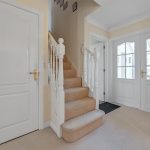 White doors and staircase in bright hallway.