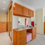 Wooden dressing table and drawers in bedroom corner