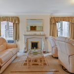 Cosy living room with fireplace and leather sofas.