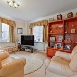 Cosy living room with beige furniture and TV.