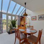 Bright dining room with skylight and plants.