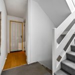 Interior hallway with staircase and wooden door