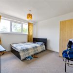 Bright bedroom with bed, wardrobe, and desk.