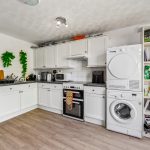 Modern kitchen with appliances and white cabinets.
