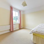 Minimal bedroom with single bed and window view.