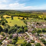 Aerial view of countryside village with fields and houses.