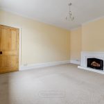 Empty room with fireplace and wooden door.