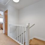 White staircase and open doors in hallway