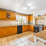 Spacious kitchen with wooden cabinets and tiled floor.