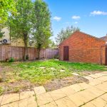 Garden with brick garage and trees in UK