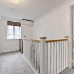 Modern landing with white railing and office space