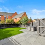 Modern garden with lawn and patio area.
