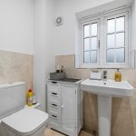 Modern bathroom with beige tiles and white fittings