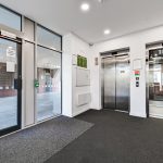 Entrance lobby with elevators and automatic doors.