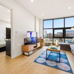Modern flat living room with large window view.