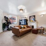 Cosy living room with brown sofa, artworks and furniture.