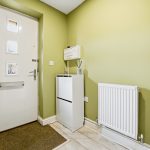 Green hallway with white door and radiator