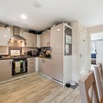 Modern kitchen with beige cabinets and dining table.