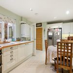 Modern kitchen with dining table and large window.
