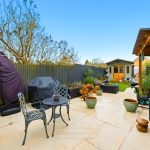 Back garden with patio furniture and shed.
