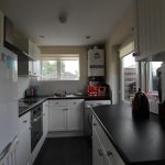 Modern kitchen with white cabinets and appliances.