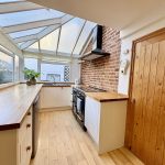 Bright kitchen with wooden countertops and brick wall.