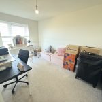 Home office with desk, chair, and packing boxes.