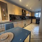 Modern kitchen with dining area and appliances.