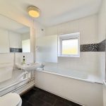 White modern bathroom with tiled accents.