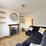 Modern living room with sectional sofa, wooden shelves.