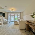 Modern living room with garden view and white decor.